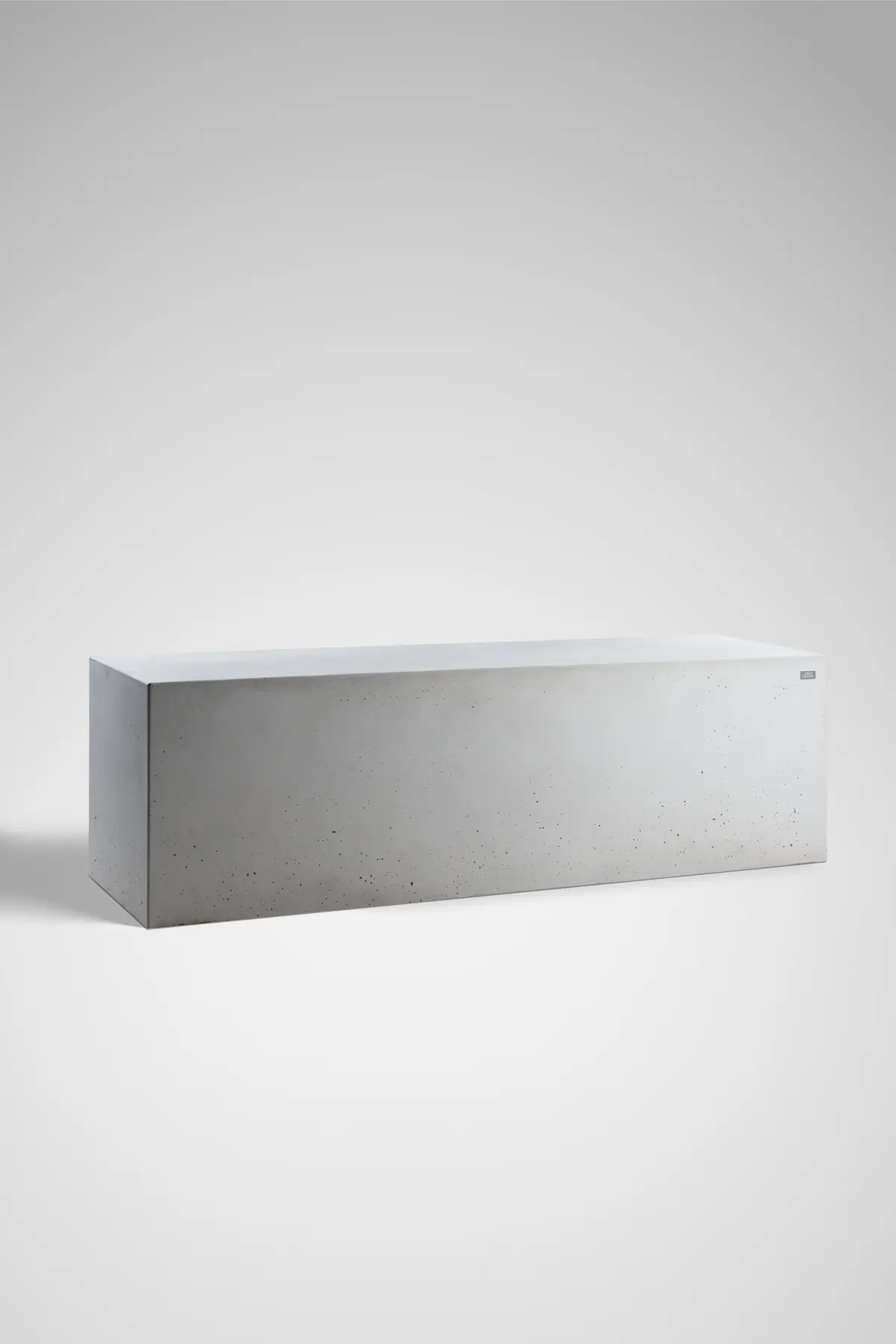 Betonkubus und massiver Betonblock als geradlinige Außenraumelemente